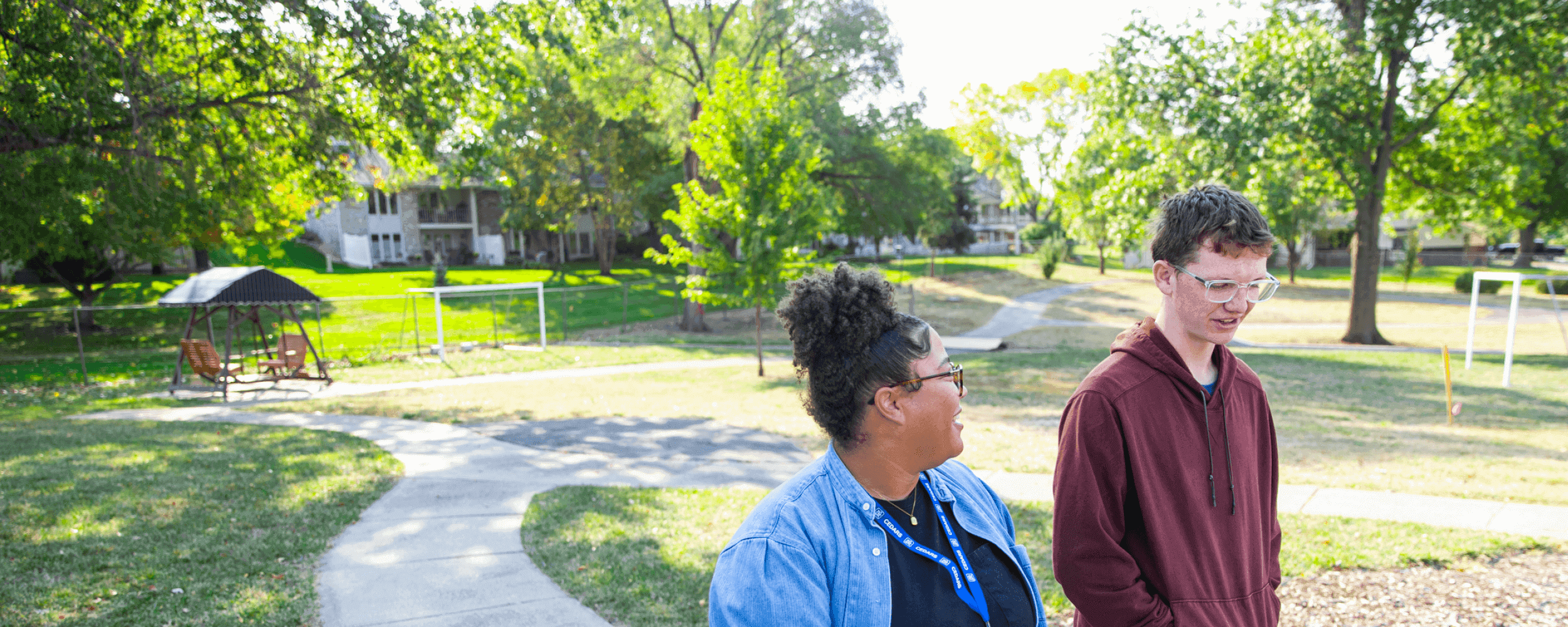 CEDARS staff member walking through the backyard with a teen boy